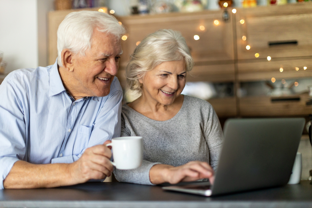 Senior,Couple,Using,Laptop,In,Their,Kitchen